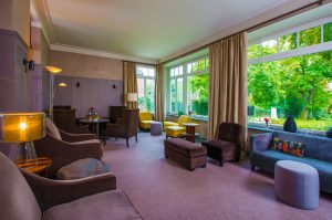Wintergarten Lounge der Eventlocation Villa Leonhart mit gemütlichen Möbeln und Blick auf den Rhein
