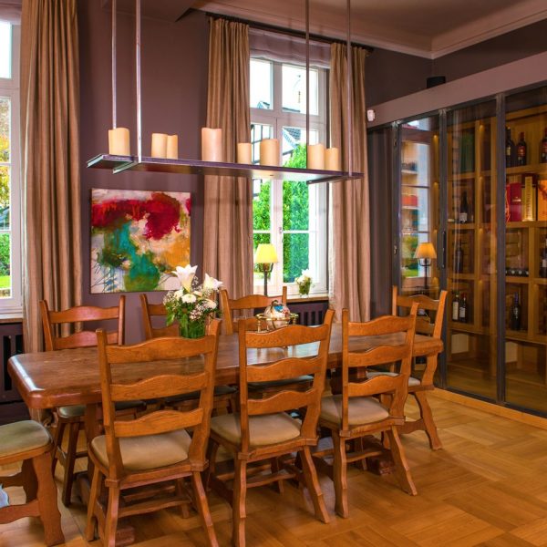 Tafelrunde-Zimmer der VILLA LEONHART mit massivem Holztisch der Platz für bis zu 10 Gäste bietet